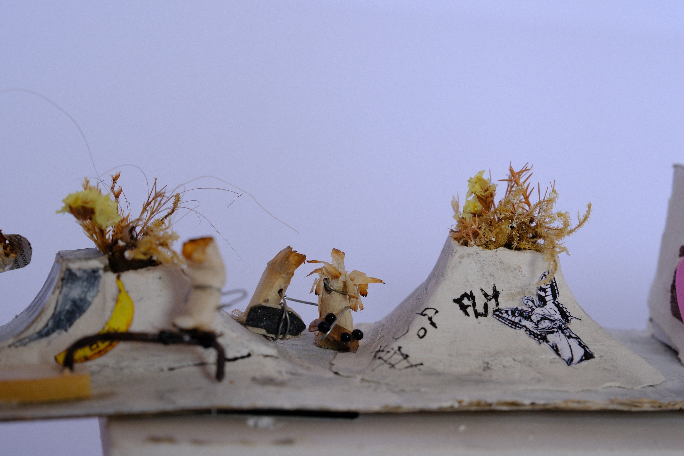 Cigarette figure wearing glasses and holding a skateboard inside the graffiti covered skate hall